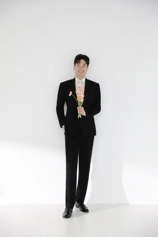 따뜻한 빛깔의 꽃다발을 든 신랑 우재