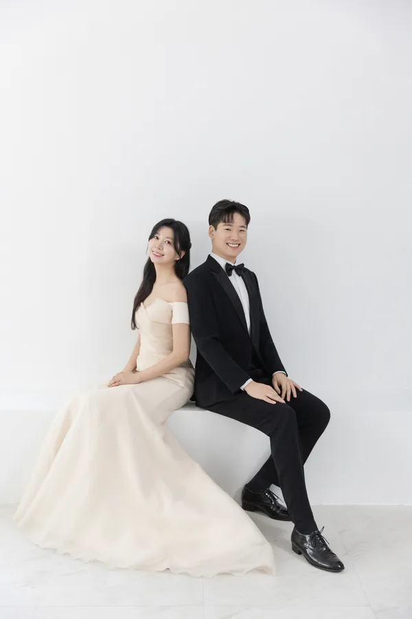 등을 맞대고 앉아 미소 짓는 두 사람