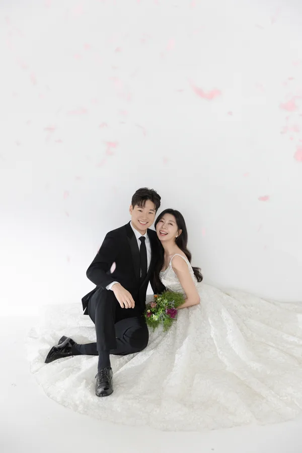 꽃잎이 흩날리는 가운데 함께 웃는 두 사람
