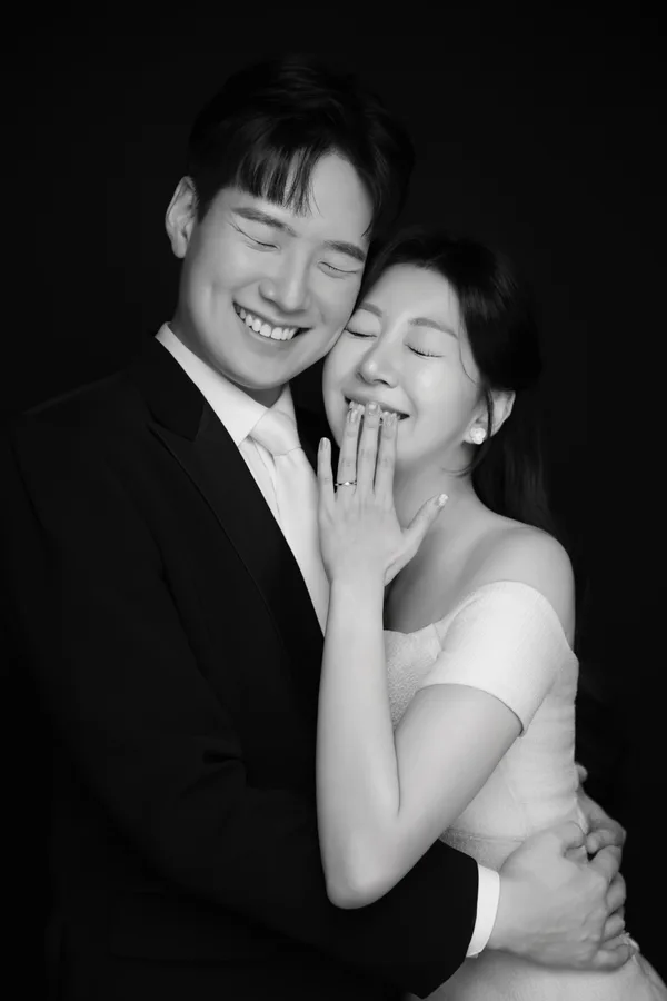 서로 안고 행복하게 웃는 두 사람의 흑백 사진