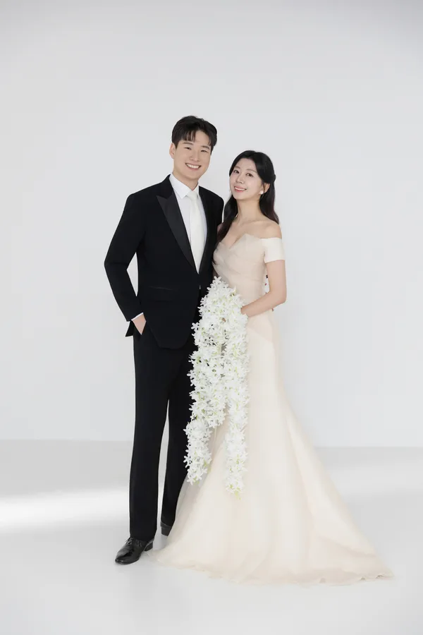 흰 꽃다발을 들고 나란히 선 두 사람