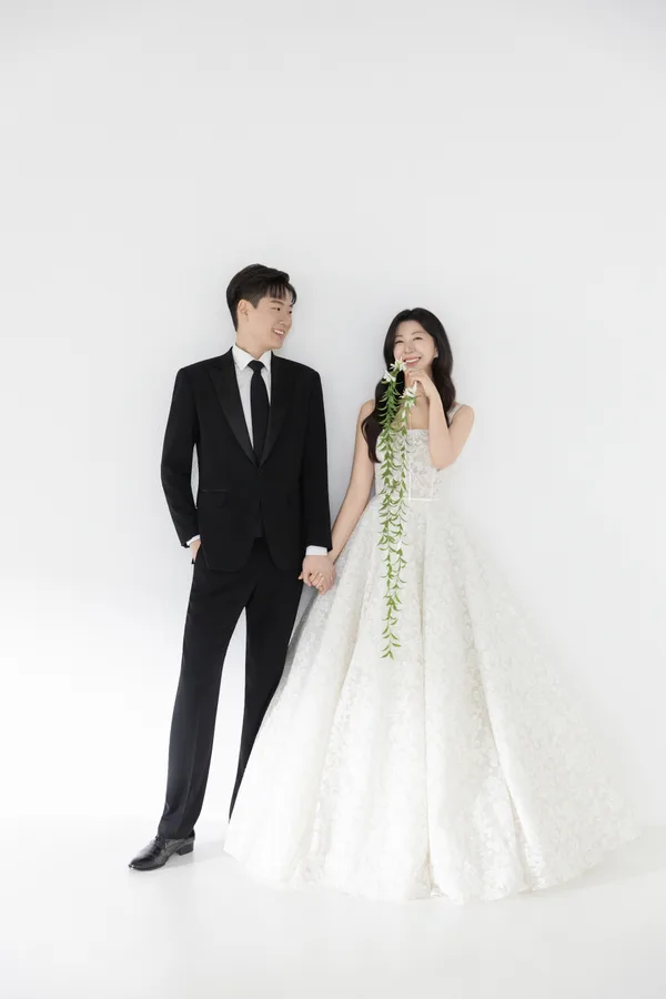 손을 맞잡고 서서 서로를 바라보는 두 사람